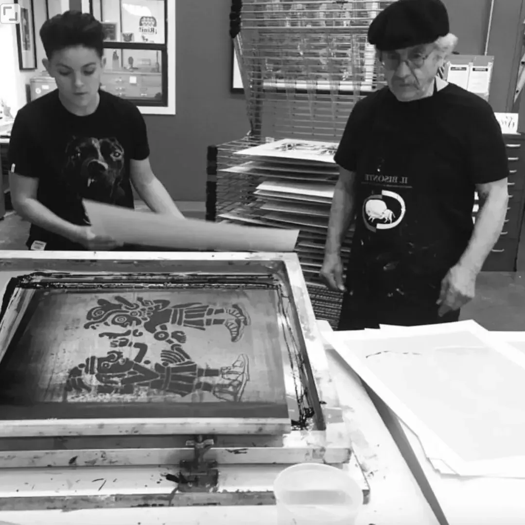 older man and child working on a screen print in black and white