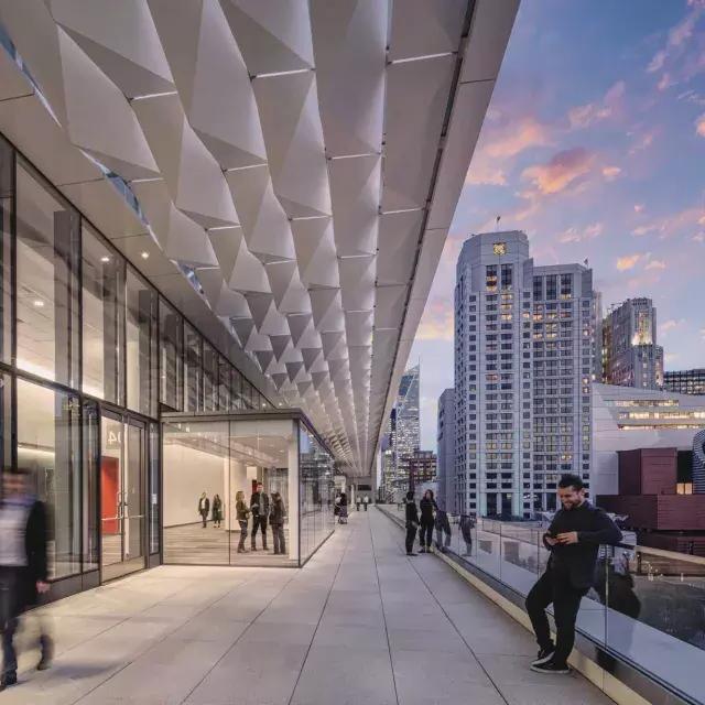 Meeting attendees stand and stroll on a balcony at Moscone Center South in San Francisco.